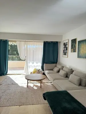 a living room with a couch and a table at Chic 2 bedroom with Huge Terrace and Pool Cannes in Cannes