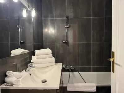 a bathroom with a sink and a shower with towels at Chic 2 bedroom with Huge Terrace and Pool Cannes in Cannes