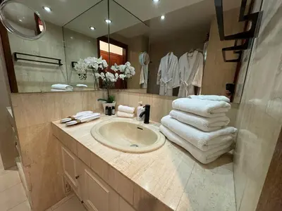 a bathroom with a sink and a mirror and towels at Chic 2 bedroom with Huge Terrace and Pool Cannes in Cannes