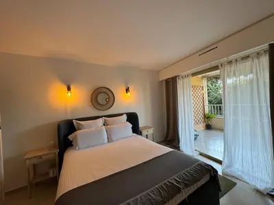 a bedroom with a large bed and a large window at Chic 2 bedroom with Huge Terrace and Pool Cannes in Cannes