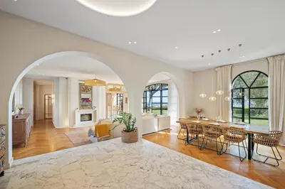 an open living room with a dining room and a dining table at Villa Grand Largue - vue mer 180° in Cannes