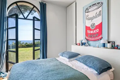 a bedroom with a bed and a large window at Villa Grand Largue - vue mer 180° in Cannes