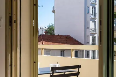 a bench sitting on a balcony looking out a window at Studio with Terrace 2 Minutes from La Croisette in Cannes