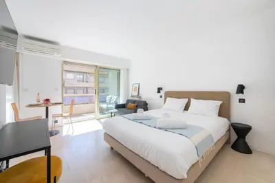 a bedroom with a large bed and a living room at Studio with Terrace 2 Minutes from La Croisette in Cannes