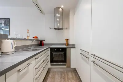 a kitchen with white cabinets and a sink at 1-Br Apartment in Cannes Walk to the Beach in Cannes