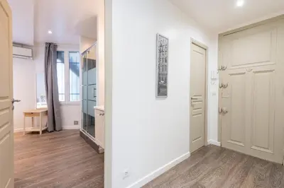 a hallway with white walls and wooden floors and a door at 1-Br Apartment in Cannes Walk to the Beach in Cannes