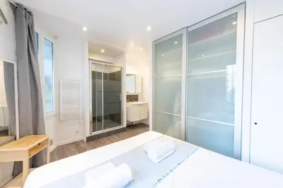 a bedroom with a bed and a glass shower at 1-Br Apartment in Cannes Walk to the Beach in Cannes