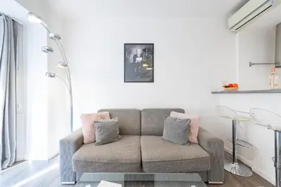 a living room with a couch and a lamp at 1-Br Apartment in Cannes Walk to the Beach in Cannes