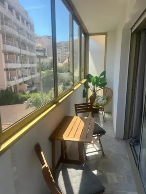 a table and chairs in a room with a window at Studio meublé, les tambourins in Cannes