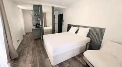 a small bedroom with a white bed and a mirror at Ref PINSON in Cannes