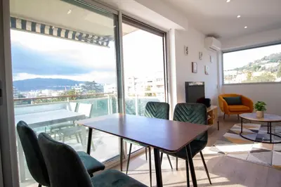 a dining room with a table and chairs and a large window at Luxury 1 Bed Apt Seafront Escape in Cannes in Cannes
