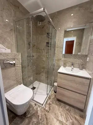 a bathroom with a shower and a toilet and a sink at Luxury 1 Bed Apt Seafront Escape in Cannes in Cannes