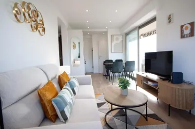 a living room with a couch and a tv at Luxury 1 Bed Apt Seafront Escape in Cannes in Cannes