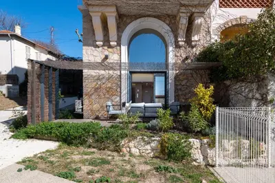 a stone house with a couch in a yard at 1-Br 75m Duplex with Pool in Cannes