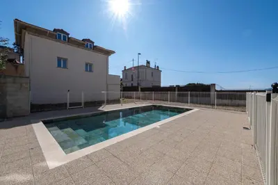 a swimming pool in front of a house at 1-Br 75m Duplex with Pool in Cannes