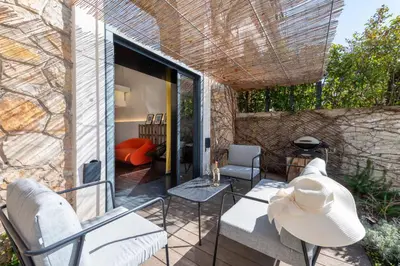 a patio with chairs and a table and a couch at 1-Br 75m Duplex with Pool in Cannes