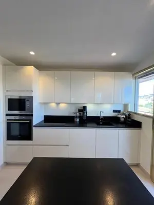a kitchen with white cabinets and a black counter top at Celeste Cannes Centre 700m du Palais des Festivals in Cannes
