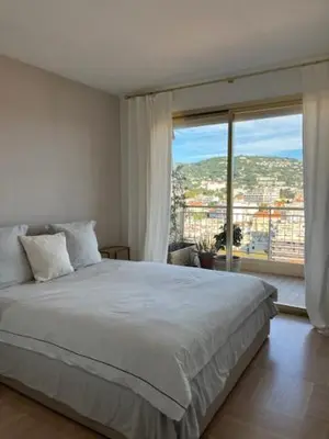 a bedroom with a large bed and a large window at Celeste Cannes Centre 700m du Palais des Festivals in Cannes