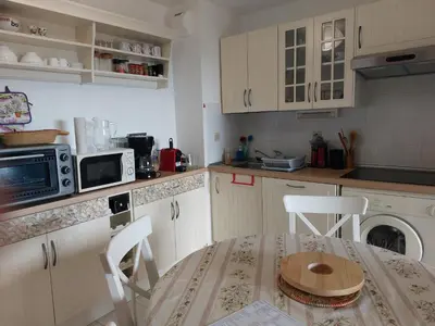 a kitchen with a table and a microwave at CARIBOU T2 piscine - Axelle Loc'Appart in Cannes