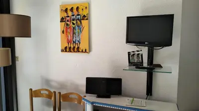 a room with a desk with a television on a wall at CARIBOU T2 piscine - Axelle Loc'Appart in Cannes