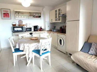 a kitchen and dining room with a table and chairs at CARIBOU T2 piscine - Axelle Loc'Appart in Cannes