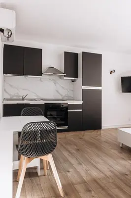 a white kitchen with a table and a chair at Perfect studio in Cannes in Cannes