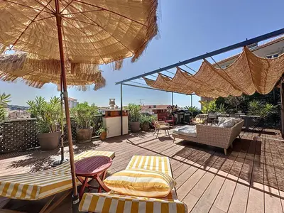 a patio with chairs and an umbrella on a deck at Intuition Rooftop vaste terrasse in Cannes