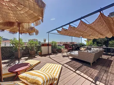 a patio with chairs and umbrellas on a deck at Intuition Rooftop vaste terrasse in Cannes