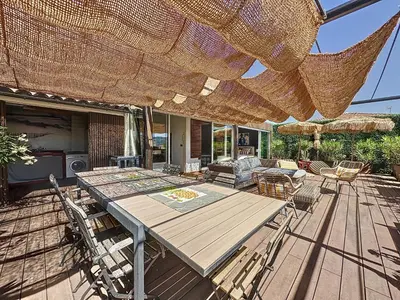a patio with a table and chairs and an umbrella at Intuition Rooftop vaste terrasse in Cannes