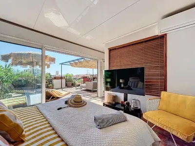a living room with a bed and a large screen tv at Intuition Rooftop vaste terrasse in Cannes