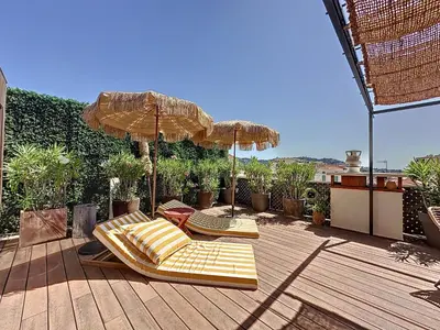 two lounge chairs and umbrellas on a deck at Intuition Rooftop vaste terrasse in Cannes