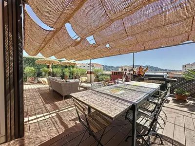 a patio with a table and chairs on a deck at Intuition Rooftop vaste terrasse in Cannes