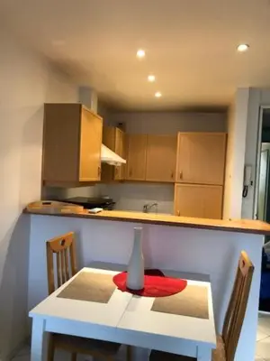 a kitchen with a table with a vase on it at merimée 4G in Cannes
