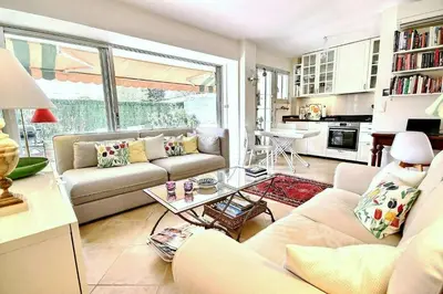 a living room with a couch and a table at magnifique 2 pièces parc de la croisette in Cannes