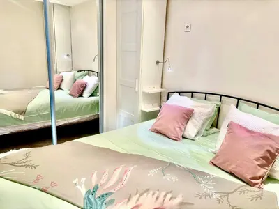 a bedroom with two beds and a mirror at magnifique 2 pièces parc de la croisette in Cannes