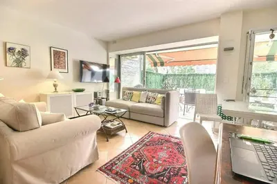 a living room with a couch and a table at magnifique 2 pièces parc de la croisette in Cannes