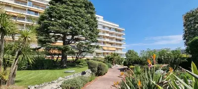 a garden in front of a large building at magnifique 2 pièces parc de la croisette in Cannes