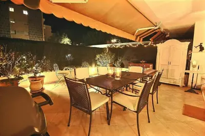 a dining table and chairs on a patio at magnifique 2 pièces parc de la croisette in Cannes