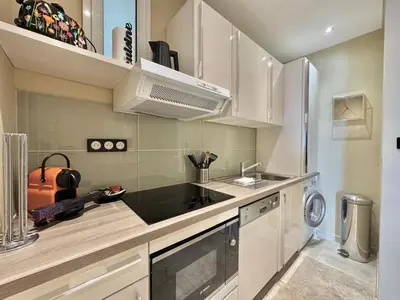 a kitchen with a sink and a stove top oven at 1-bedroom apartment with balcony and sea view on La Croisette in Cannes