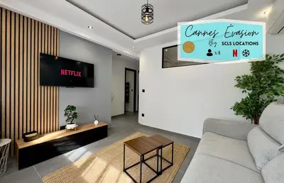 a living room with a couch and a tv at Cannes Évasion by SCLS Locations in Cannes