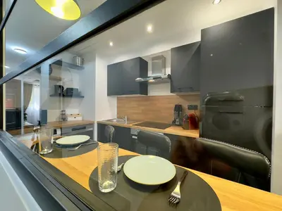 a kitchen with a table with chairs and a counter top at Cannes Évasion by SCLS Locations in Cannes
