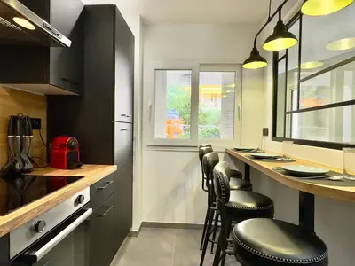 a kitchen with a bar with stools and a counter at Cannes Évasion by SCLS Locations in Cannes