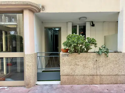 a building with two potted plants on a brick wall at Cannes Évasion by SCLS Locations in Cannes