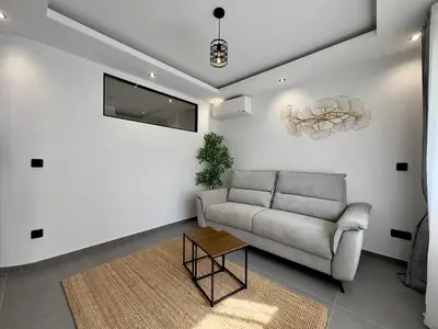 a living room with a couch and a table at Cannes Évasion by SCLS Locations in Cannes
