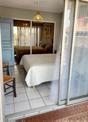 a bedroom with a bed and a living room at A 2 pas des plages du Midi 300L in Cannes