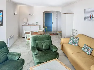 a living room with two green chairs and a table at A 2 pas des plages du Midi 300L in Cannes