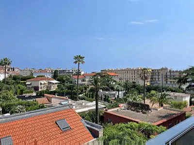 a view of a city with palm trees and buildings at A 2 pas des plages du Midi 300L in Cannes