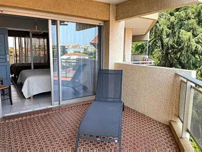 a chair sitting on a porch with a view of a bedroom at A 2 pas des plages du Midi 300L in Cannes