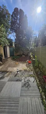 a backyard with a wooden deck with the sun in the background at F3 ground floor, Hypercentre 2 min from Palace in Cannes