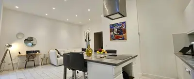 a kitchen and living room with a table and a couch at F3 ground floor, Hypercentre 2 min from Palace in Cannes